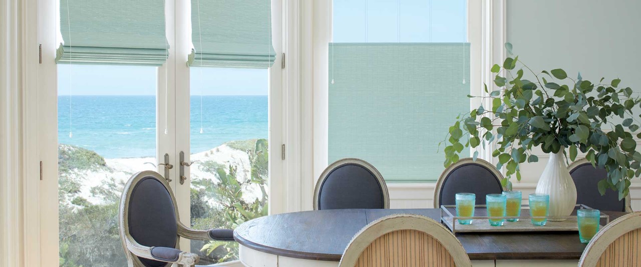 Coastal dining room table with woven wood shades.